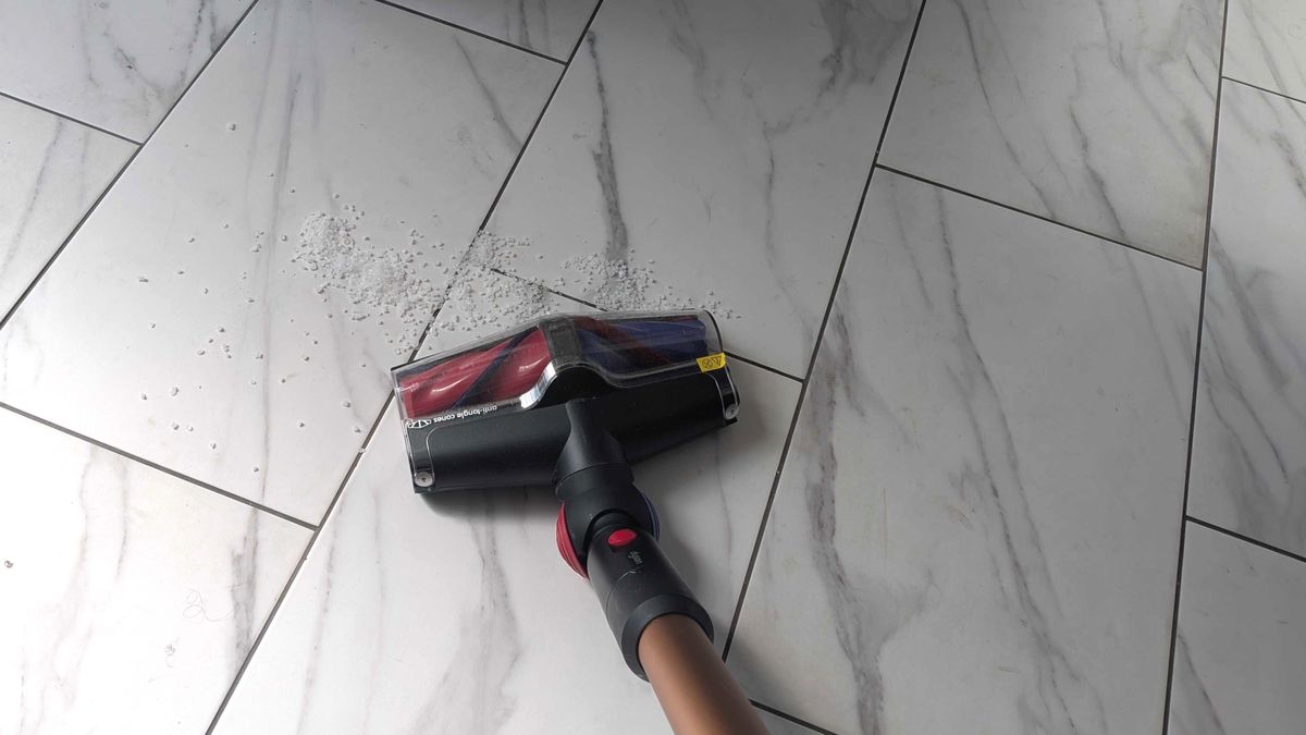 Dyson V16 Animal Piston cleaning debris on the whilte floor tiles