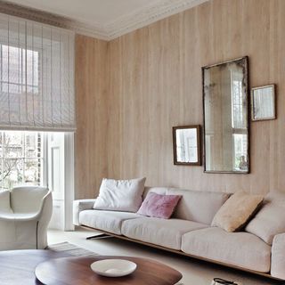 living room with neutral sofa and wood effect wallpaper