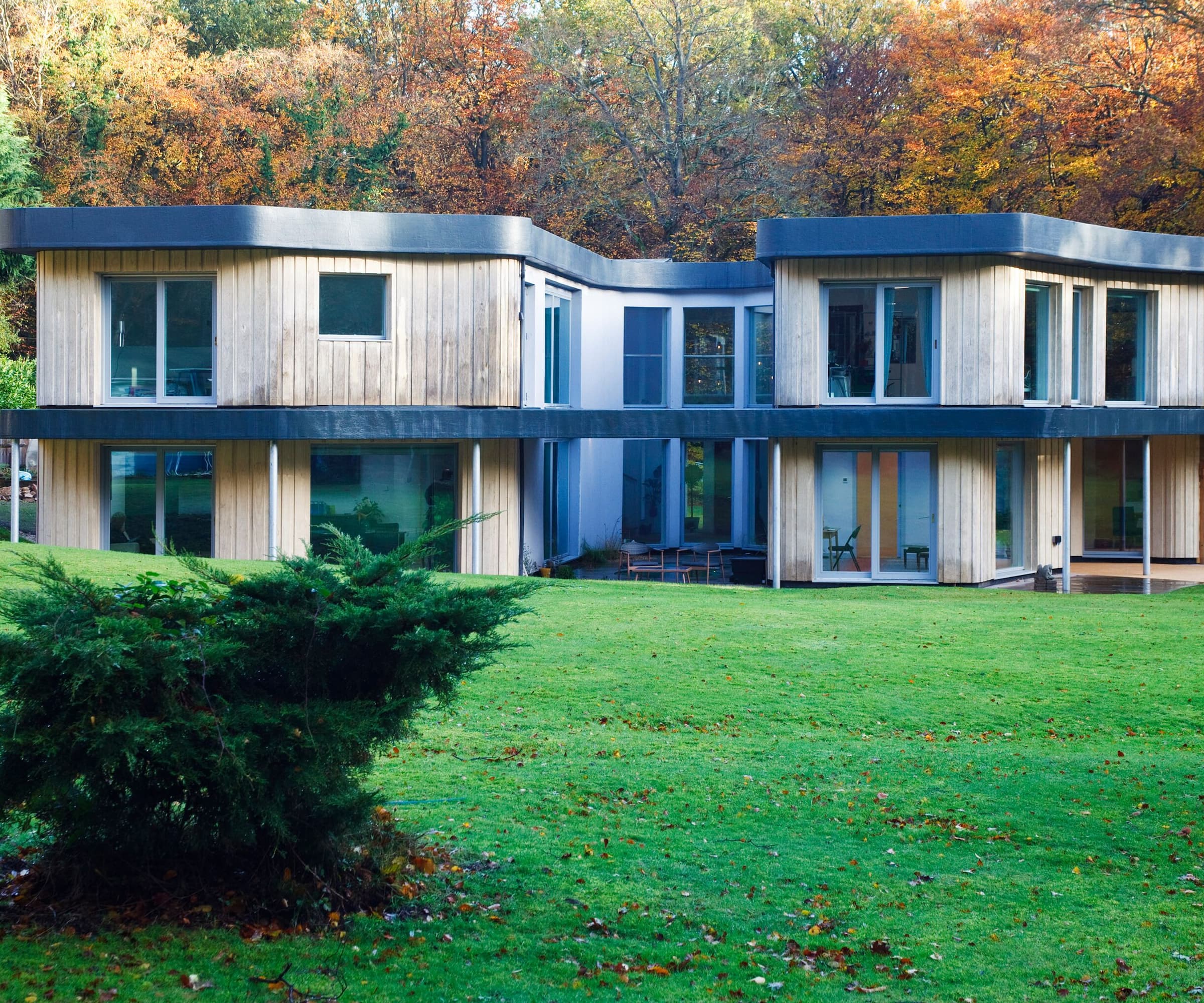 A garden with a bush leading onto a two-storey self build