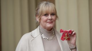 Sarah Lancashire poses after she was awarded an OBE by Duke of Cambridge