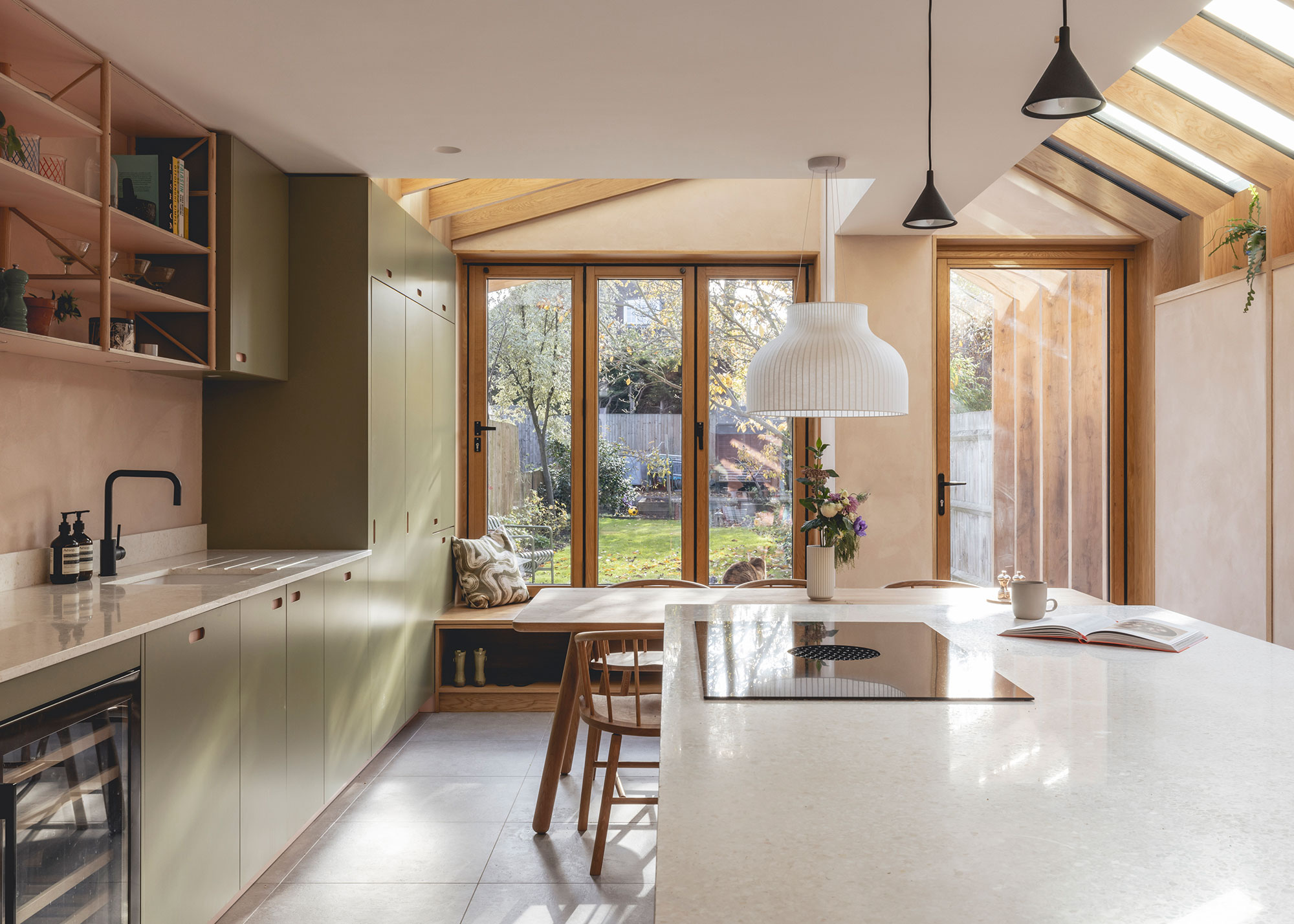 modern kitchen extension with glazed ceiling and bifold windows and window seat