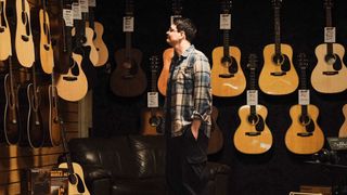 Customer looking at acoustic guitars in a guitar store