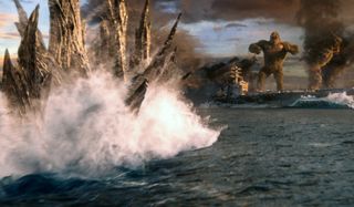 Godzilla swims towards Kong, standing on a battleship, in Godzilla vs. Kong.