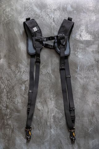 The BlackRapid Double Breathe Dual Camera Harness Strap on a metallic background