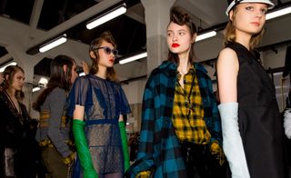 Models wear checkered shirts and overcoats with long coloured gloves