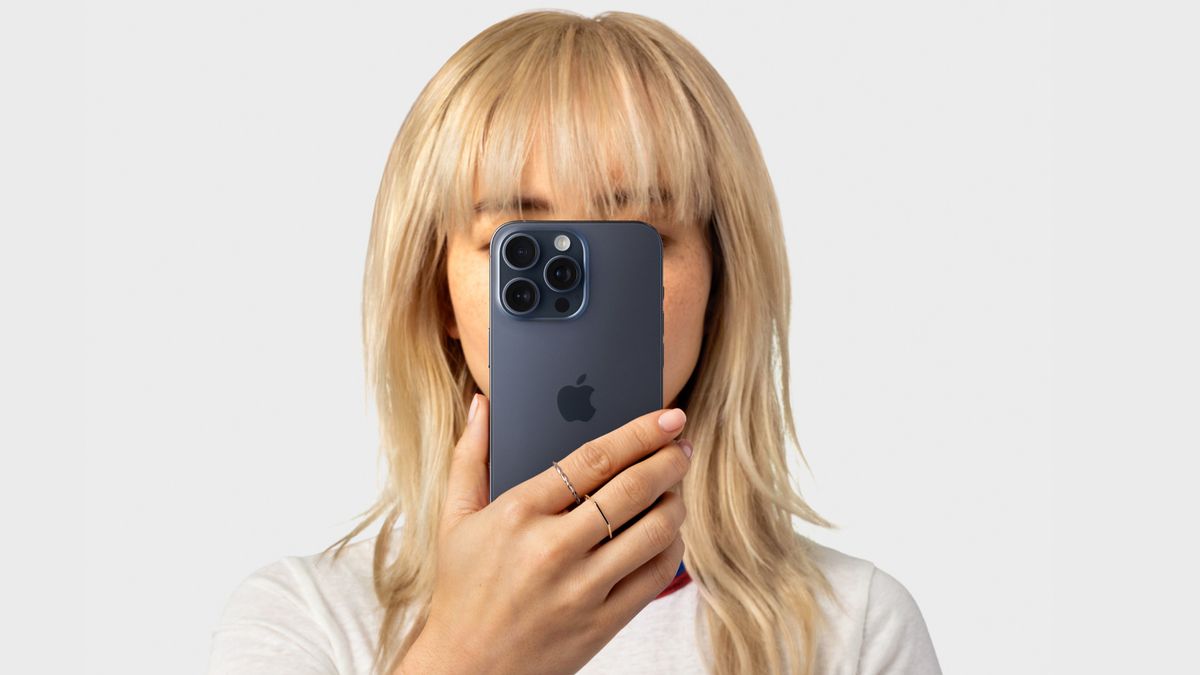 A woman holding an iPhone up to her face