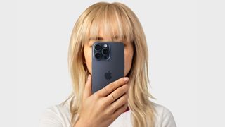 A woman holding an iPhone up to her face