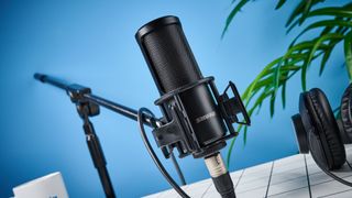 the Shure sm4 condenser musician microphone photographed against a blue background with a physical magnetic pop filter