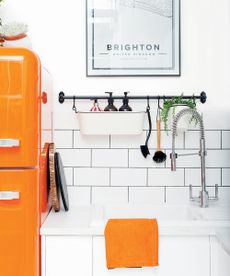 kitchen area with orange fridge and wash basin