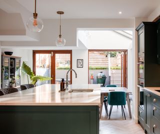 open plan kitchen extension with green units and white worktop