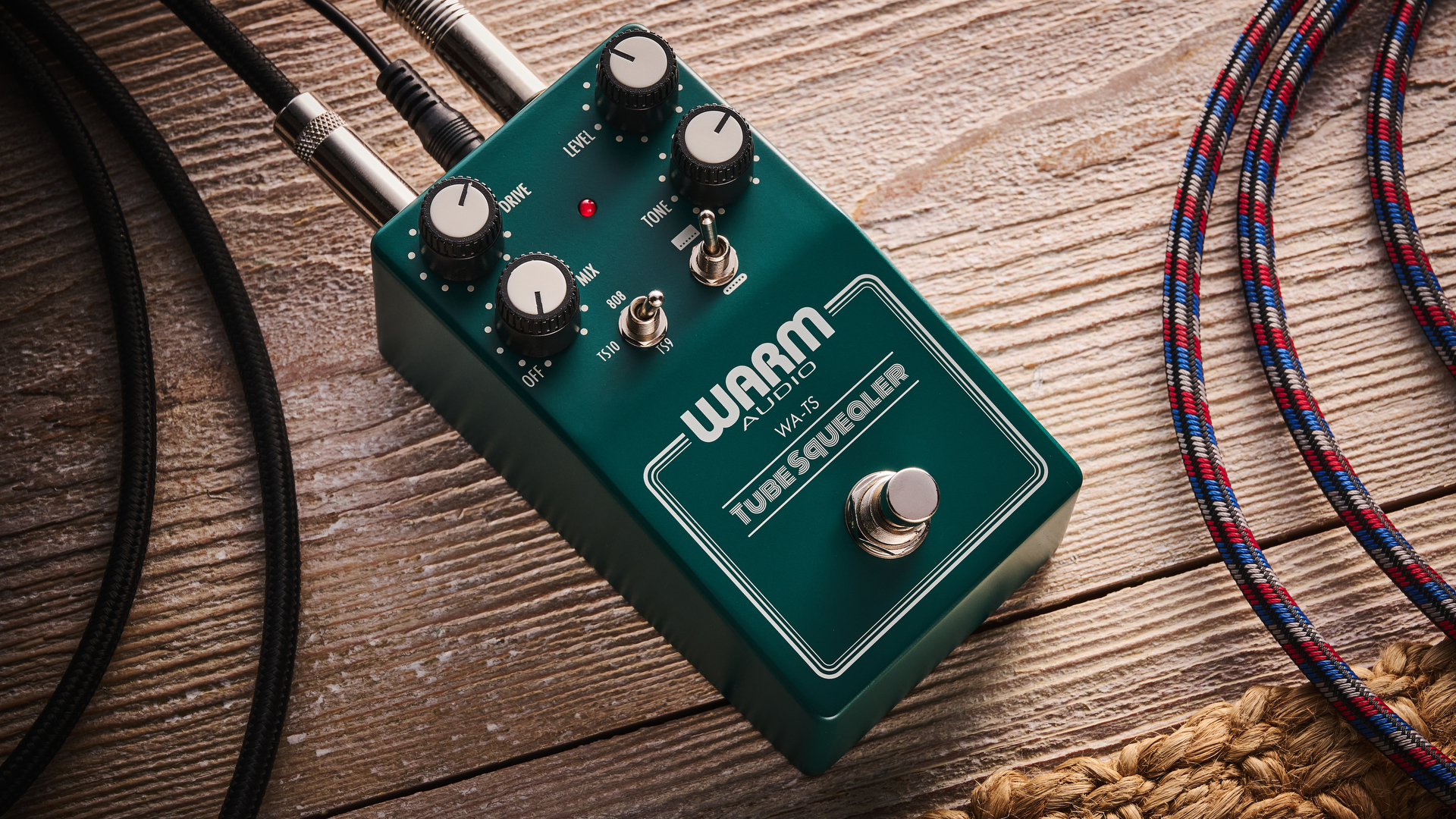 Warm Audio Tube Squealer green overdrive pedal shot on wood floorboards