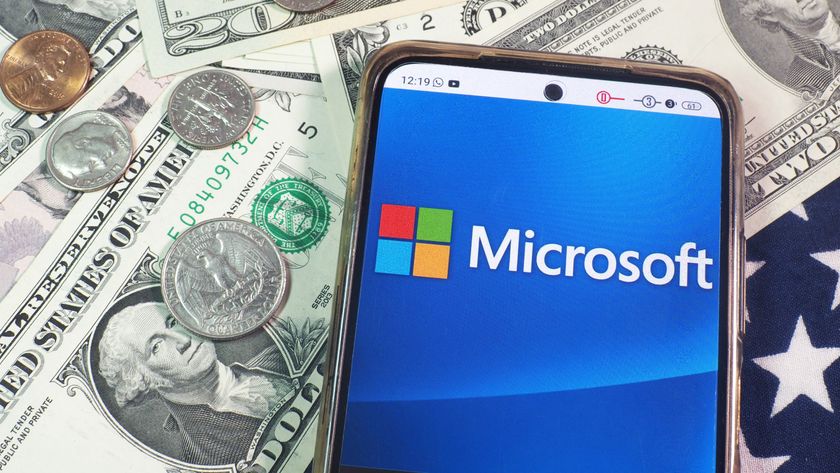 Microsoft Corporation logo seen displayed on a smartphone with United States Dollar notes and coins in the background.