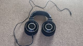 The OneOdio Monitor 60 Wired Headphones pictured on a pale carpeted surface