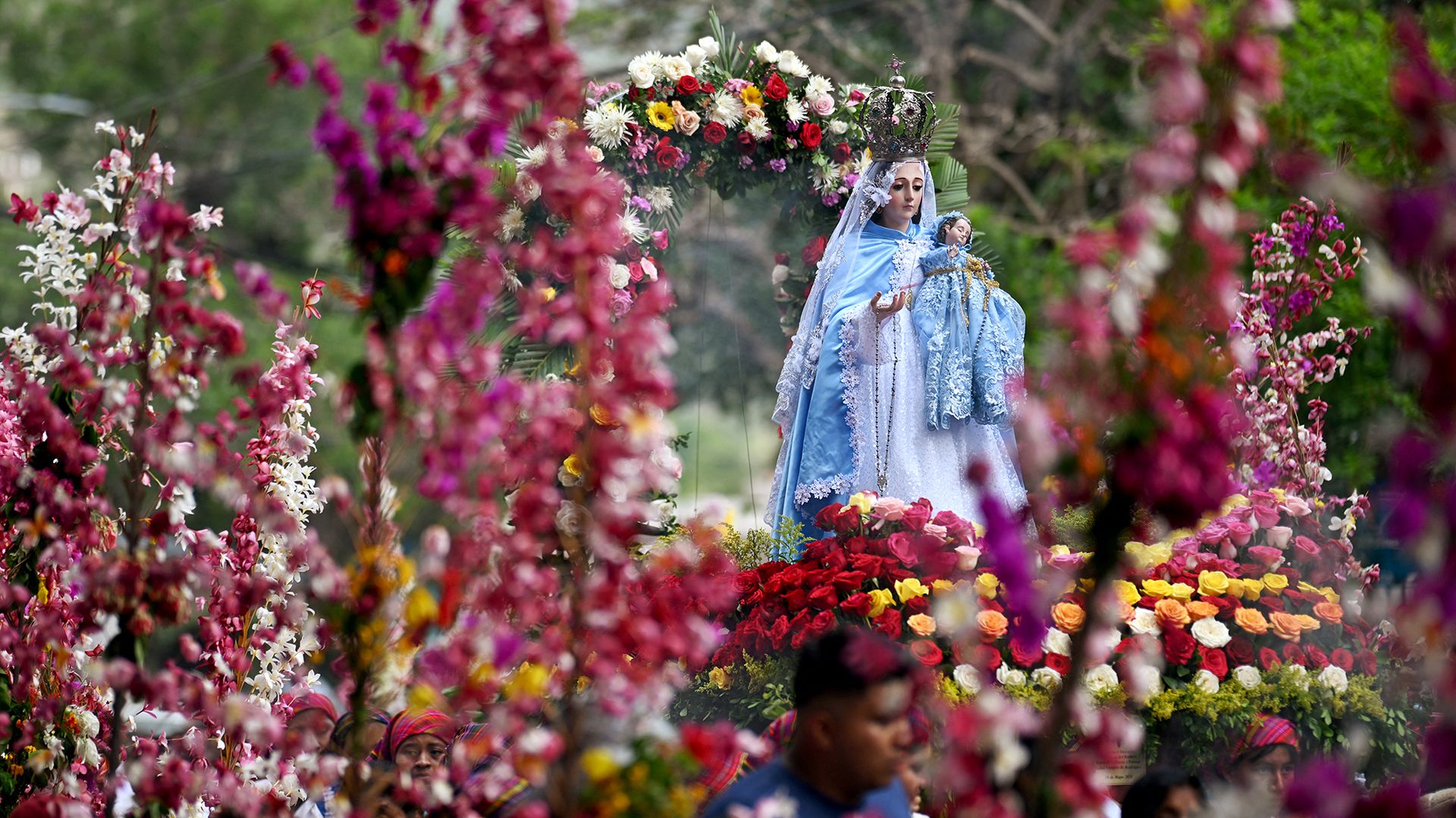
                                A statue of Mary is carried through the streets during the annual Flowers And Palms festival in Panchimalco, El Salvador, part of a religious celebration that mixes Catholic and indigenous beliefs
                            