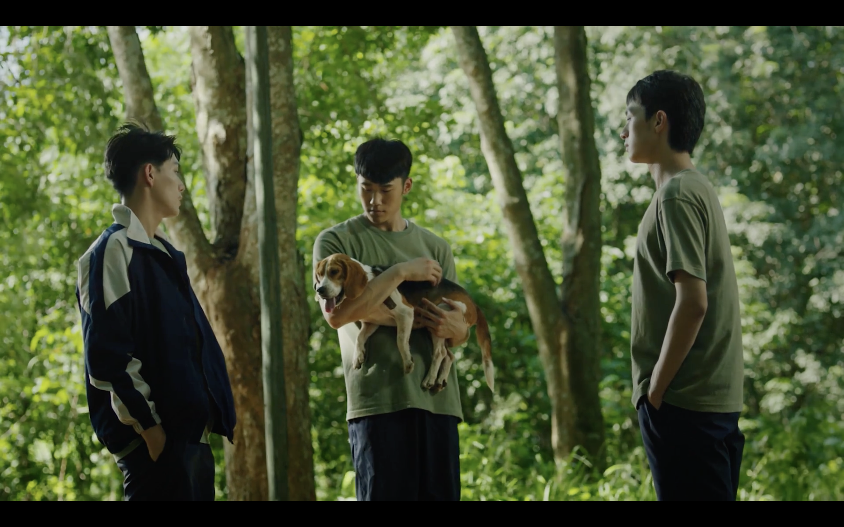 Three students in Breakout 13, one cradling his pet dog in his arms.