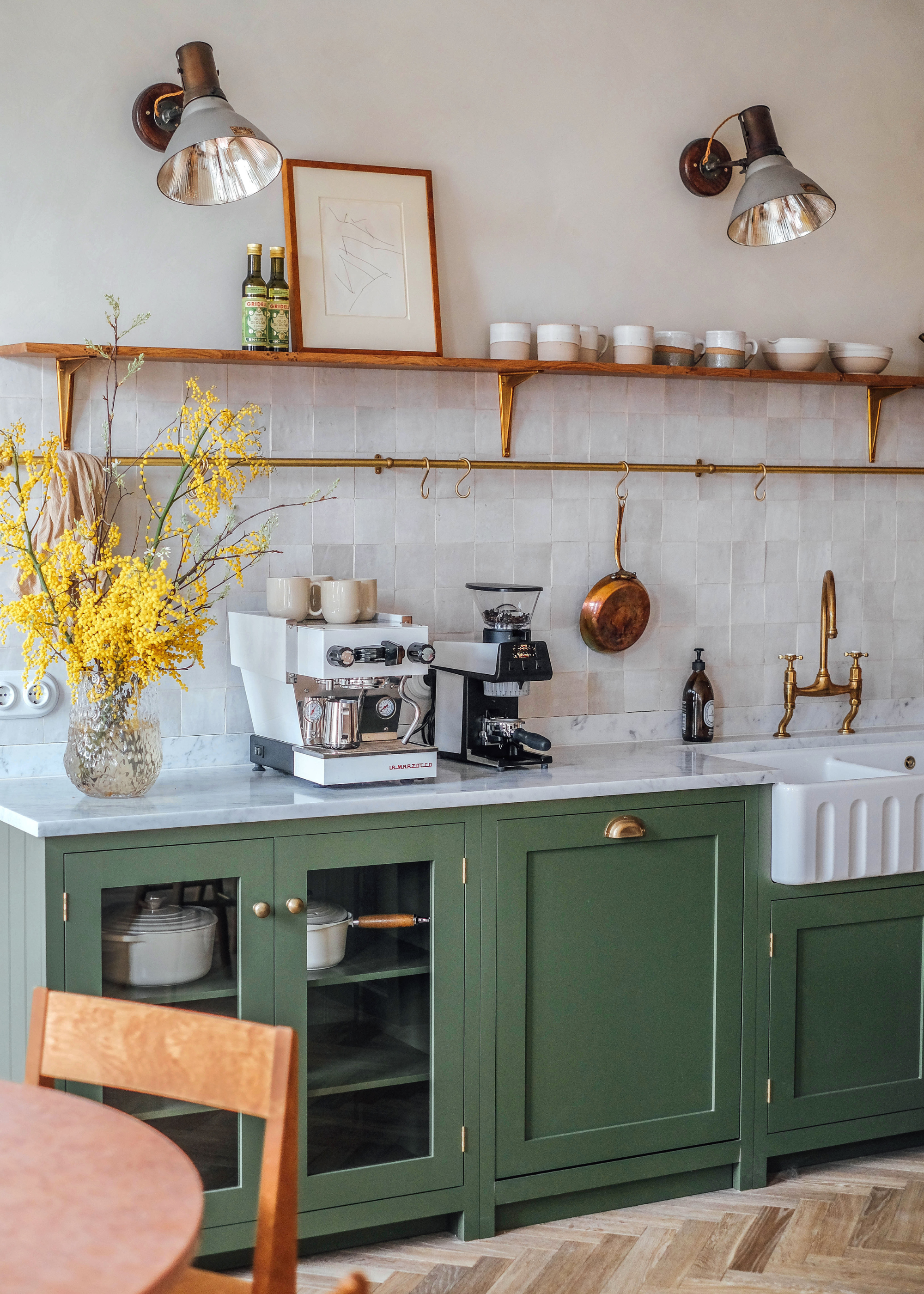 kitchen with dark green cabinetry and a wooden shelf, and white zellige tiles