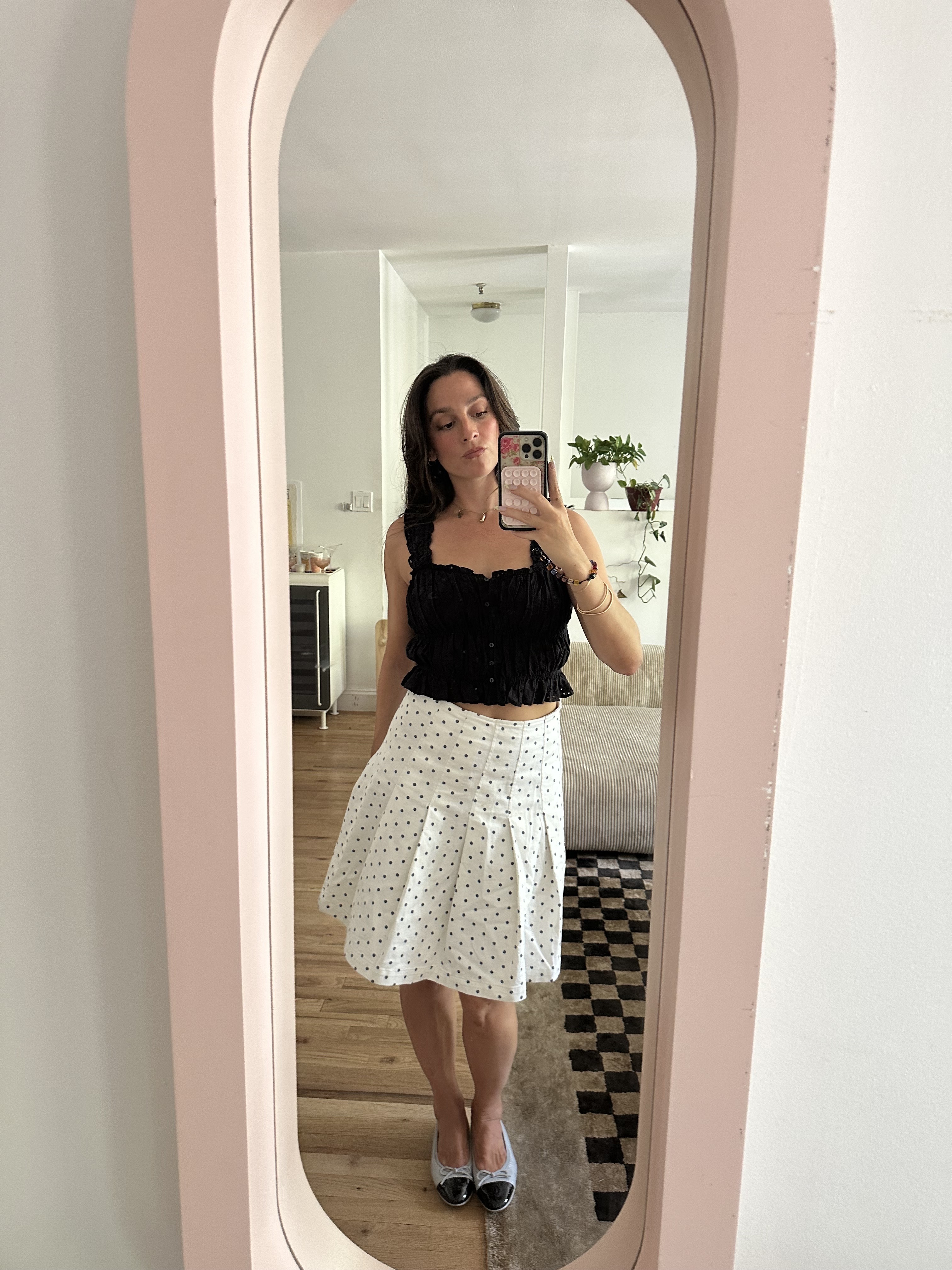 Tara Gonzalez taking selfies in a polka dot skirt.