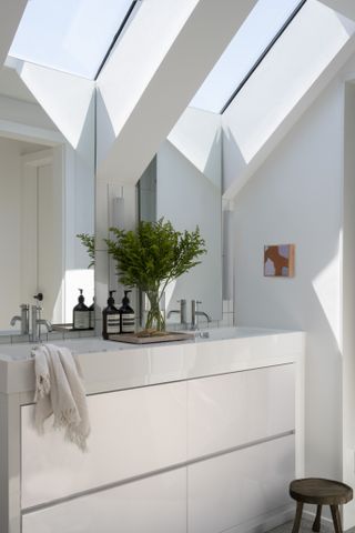 white attic bathroom with skylights