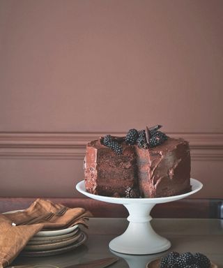 brown walls behind cake stand with cake on it