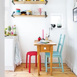 Wooden table with colourful chairs