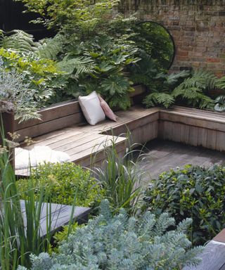 Small garden with wraparound wood seating and decking