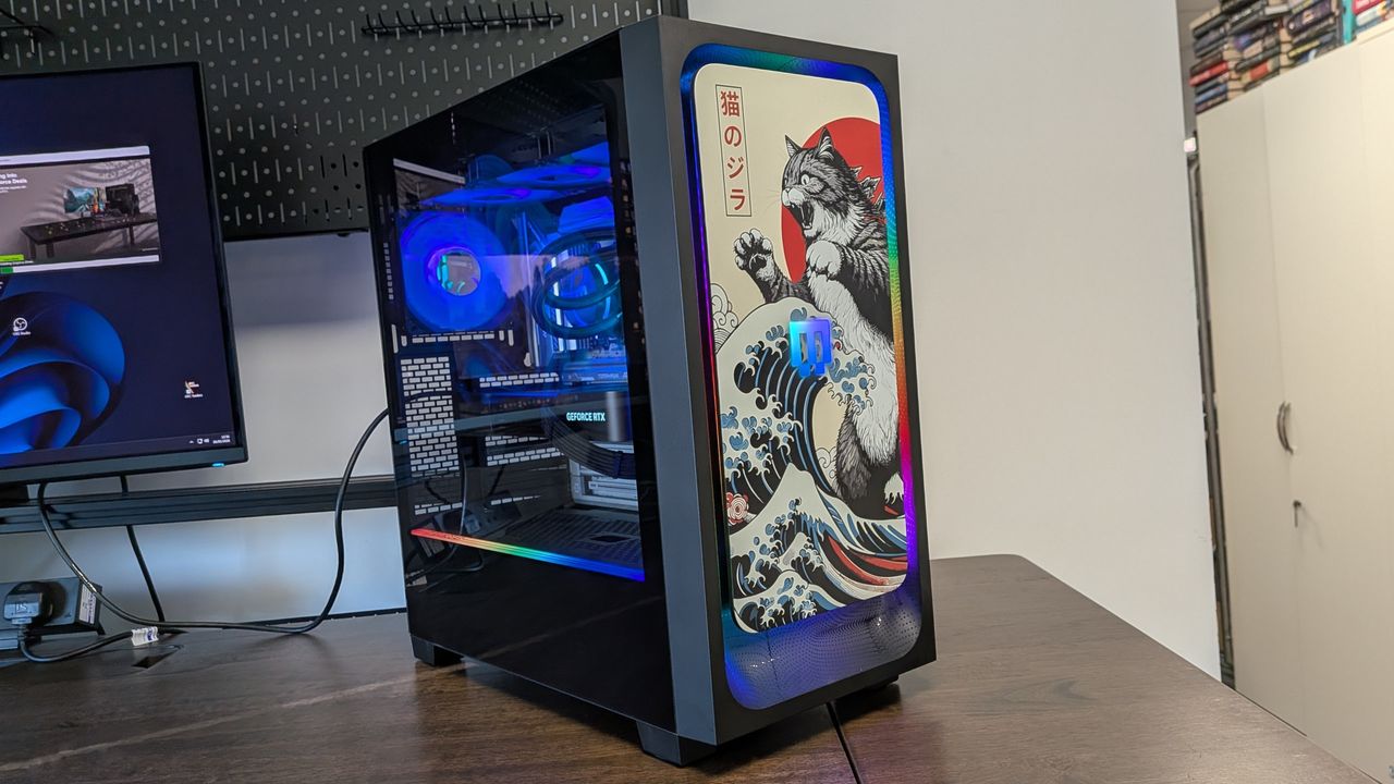 A photo of a Maingear MG-1 Mk.II gaming PC on a desk, showing a custom panel front panel installed