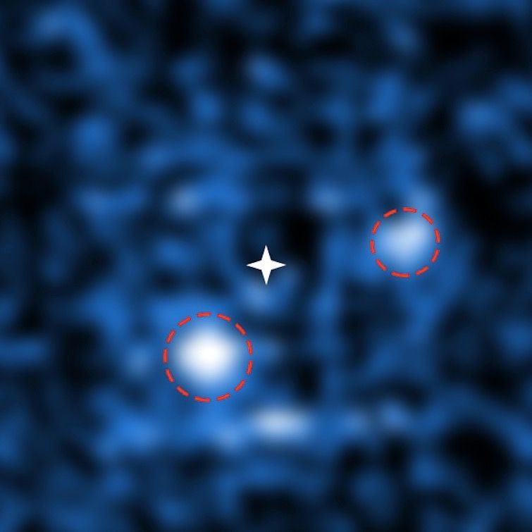 PDS 70 is only the second multiplanet system to be directly imaged. Through a combination of adaptive optics and data processing, astronomers were able to cancel out the light from the central star (marked by a white star) to reveal two orbiting exoplanets. PDS 70b (lower left) is four to 17 times more massive than Jupiter, while PDS 70c (upper right) is one to 10 times more massive than Jupiter.