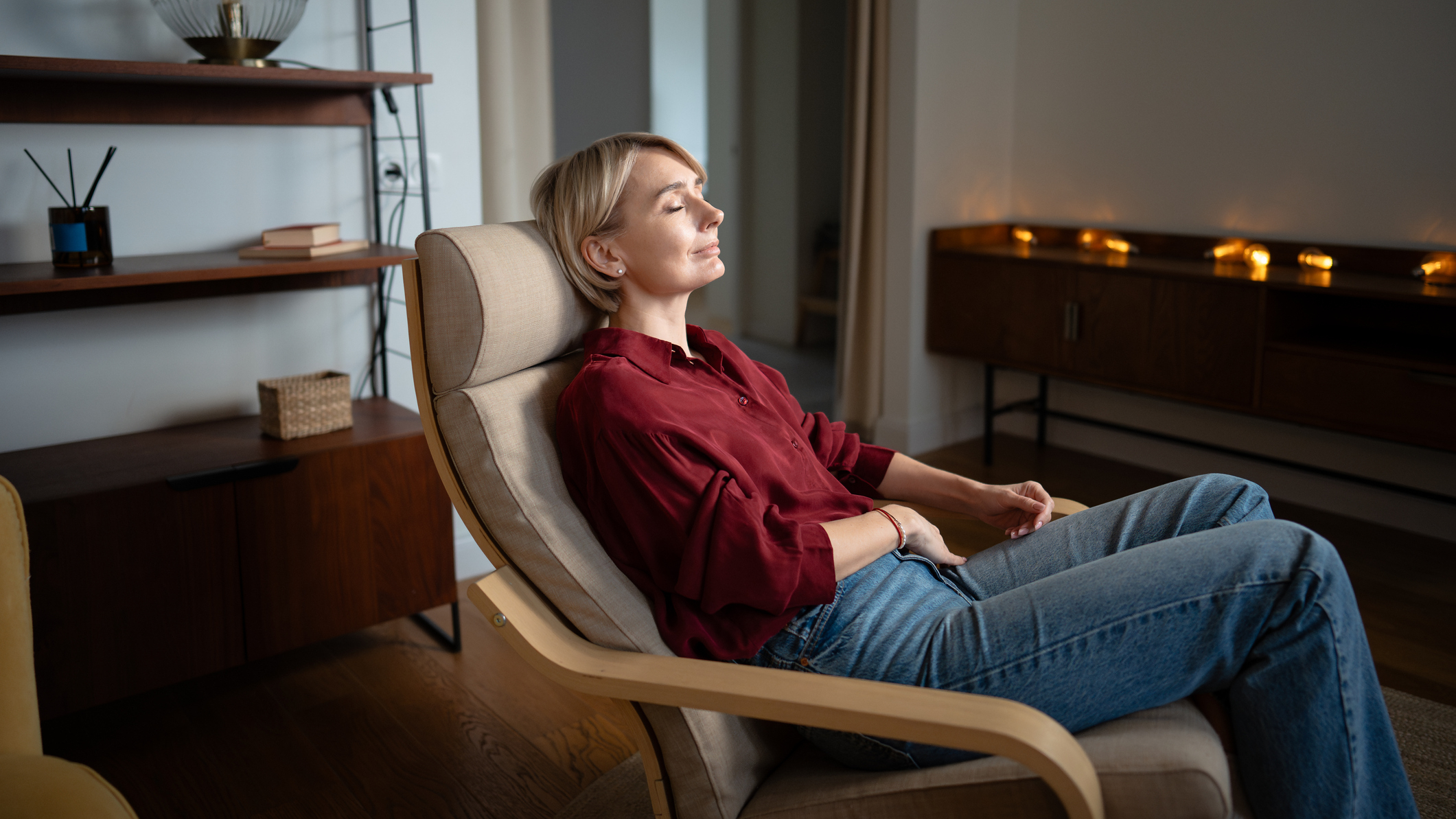 Woman sitting in armchair with eyes closed