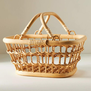A product shot of a wicker basket with handle