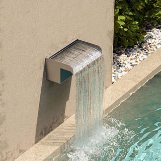 Water spout on the edge of a pond pouring water 