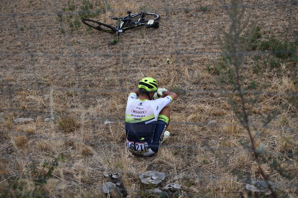 Team Wanty rider Belgiums Quinten Hermans sits in a field after falling during the first stage of the 72nd edition of the Criterium du Dauphine cycling race 2185 km between ClermontFerrand and SaintChristoenJarez on August 12 2020 Photo by AnneChristine POUJOULAT AFP Photo by ANNECHRISTINE POUJOULATAFP via Getty Images