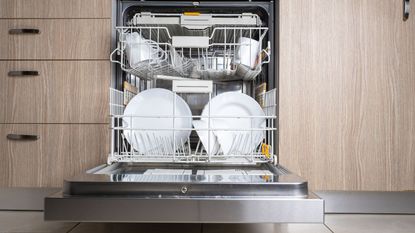 The best dishwashers look like this: stylish, well-stacked with clean plates. the door is open of this built-in washer, flush with wooden cabinets