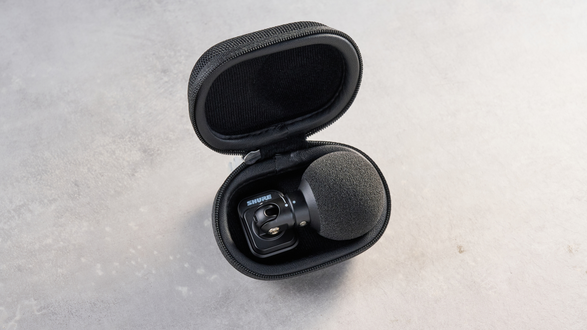 the shure mv88 usb-c microphone photographed against a blue tom's guide background and shown connected to a google pixel 10 pro