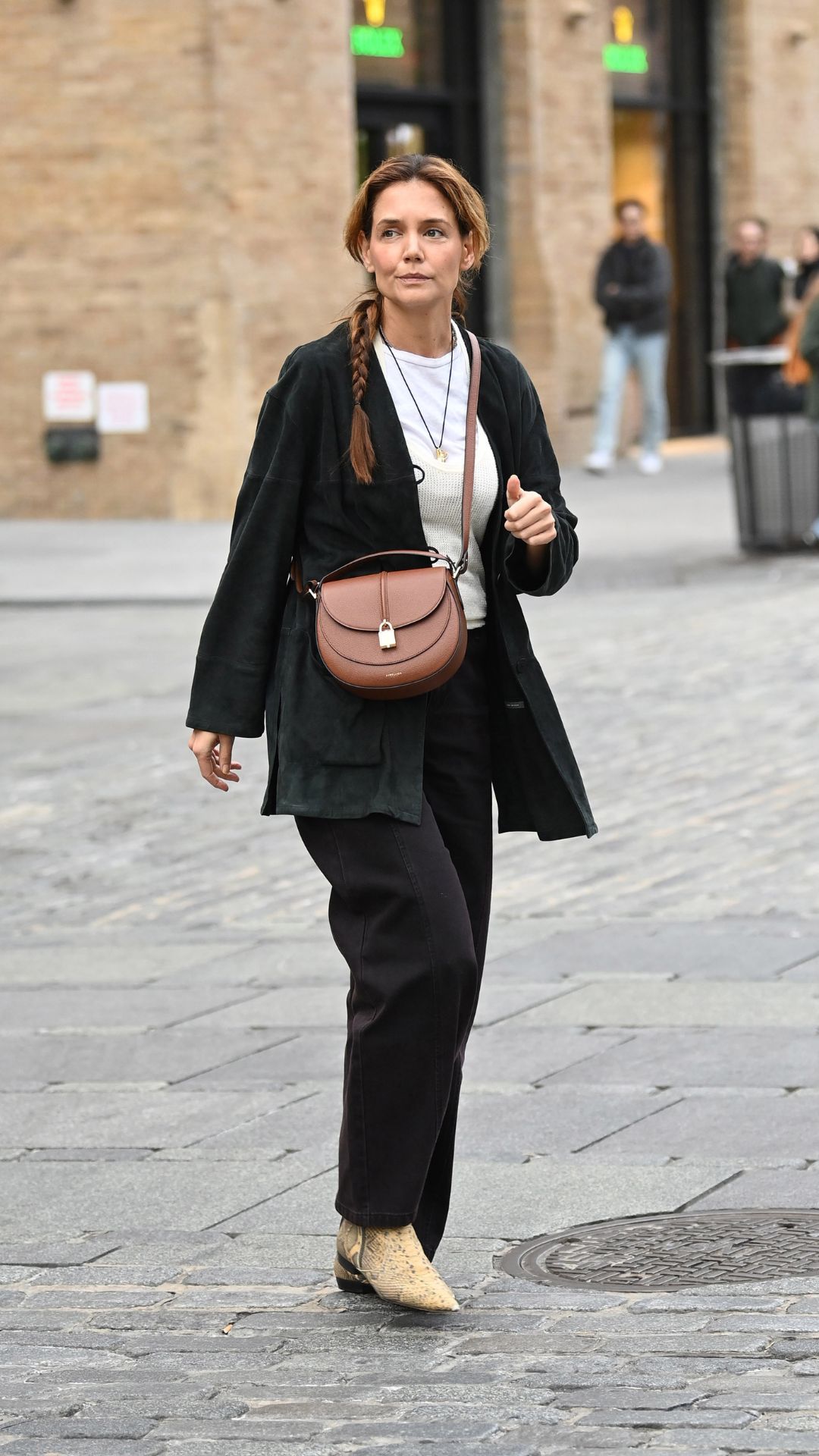 Katie Holmes spotted with her hair in a long braid and wearing a Demellier bag on October 29, 2025 in New York City