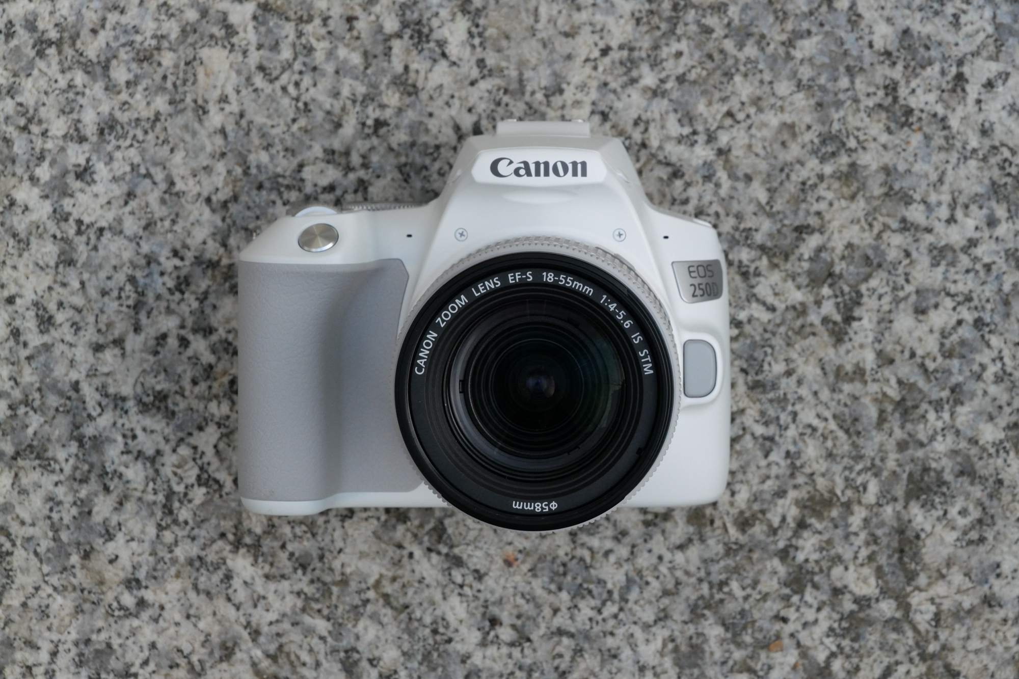 The Canon Rebel SL3 / EOS 250D, one of the best Canon cameras, placed on a stone floor
