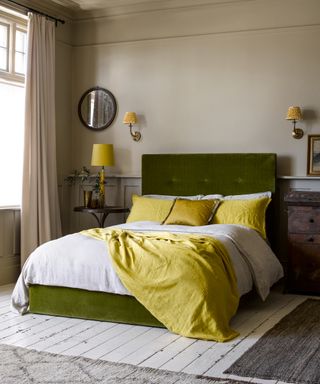A bedroom wall lighting by Pooky with green bed and yellow bed accessories including cushions and throw