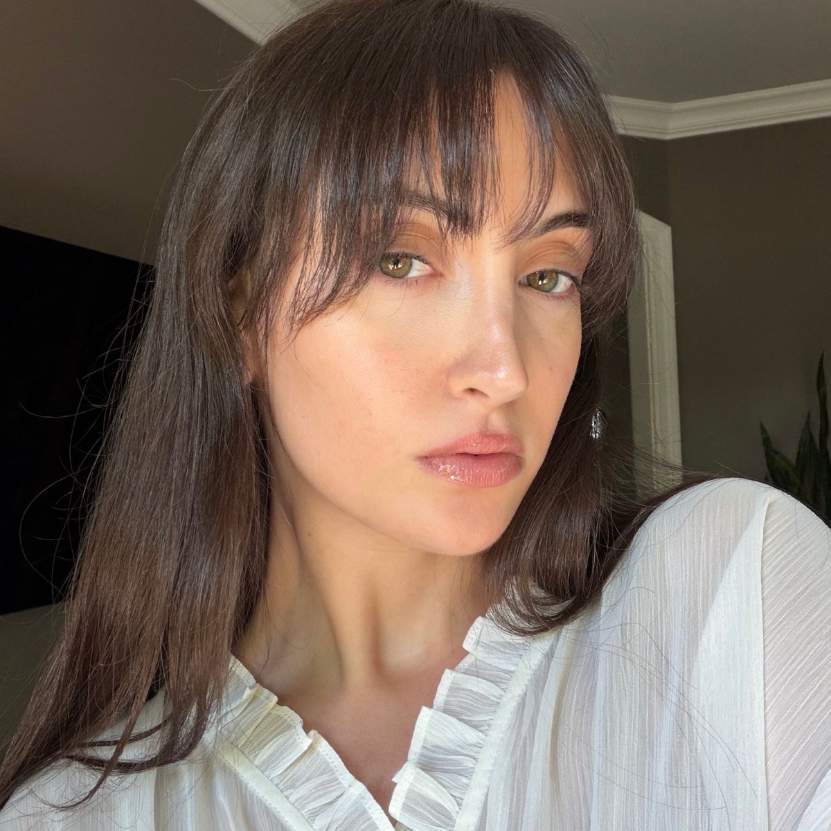 A split image of Who What Wear associate beauty editor Alyssa Brascia after 14 days of wearing the Omnilux Contour Face Mask and the device lying on a bedspread.