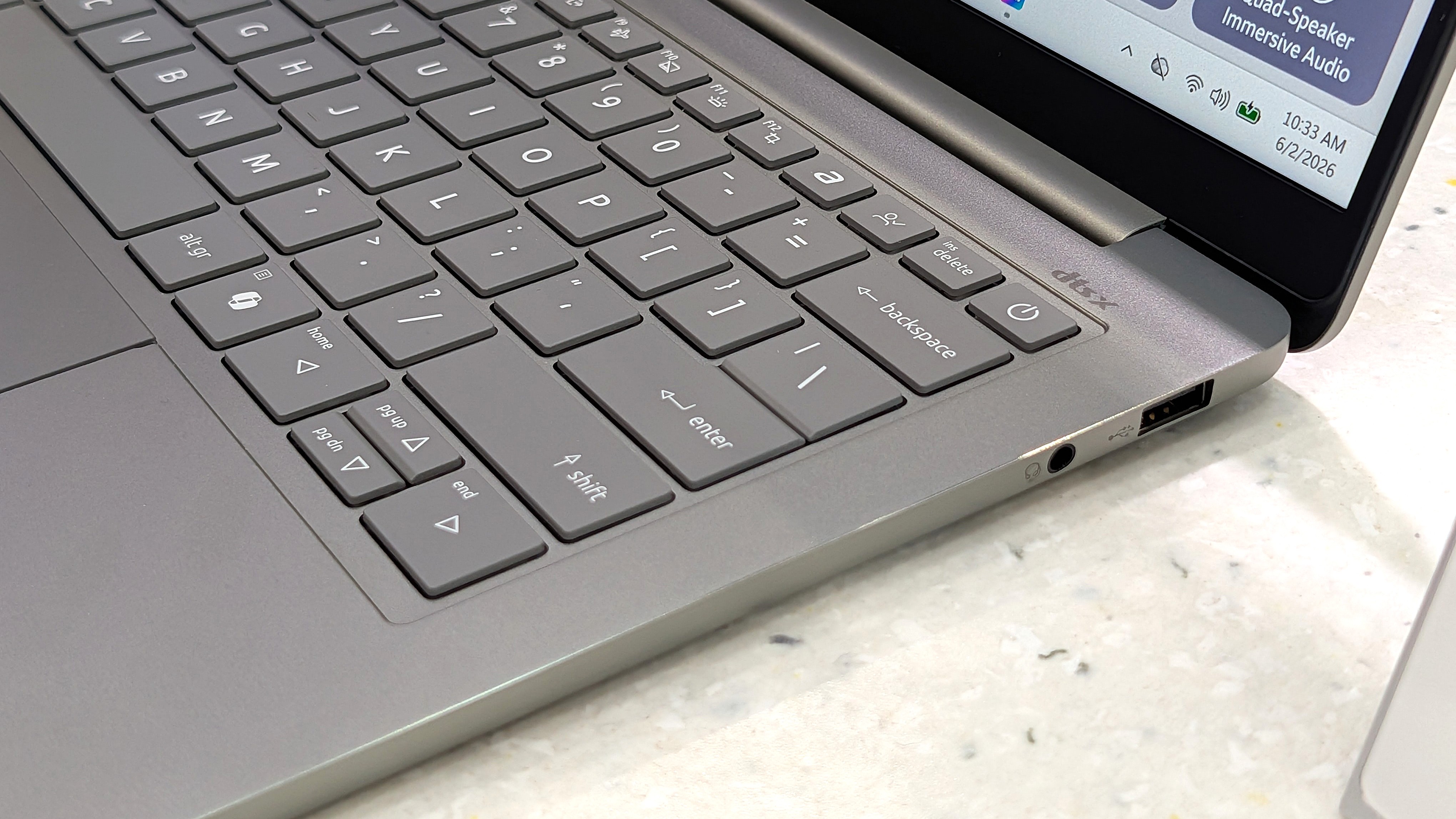 Acer Swift Air 14 laptop sitting on a marble desk, with a section of the keyboard in view next to ports.