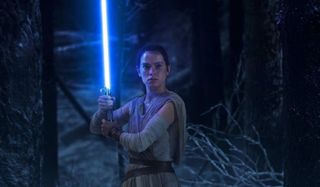 Rey and lightsaber in Star Wars: The Force Awakens