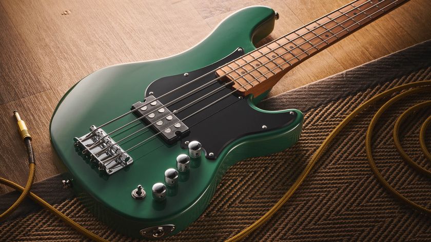 The Cort GB Short-scale Bass finished in green, photographed against a light wooden floor and rug.