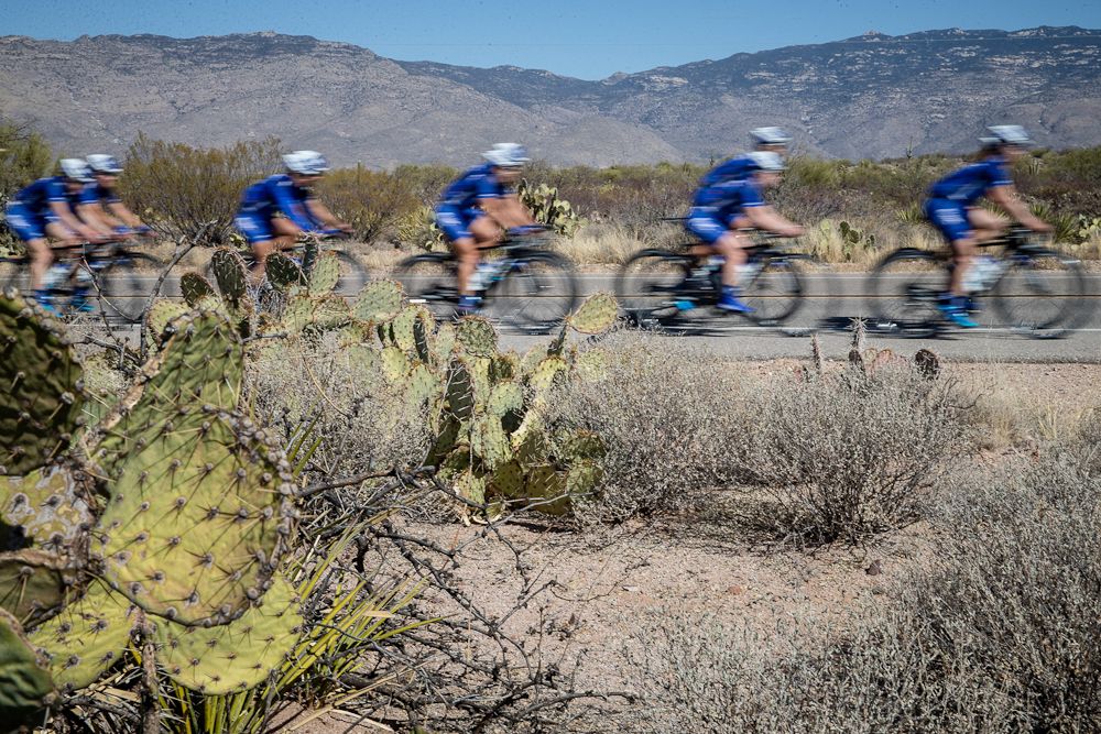 UnitedHealthcare riders blur as they pass some local flora