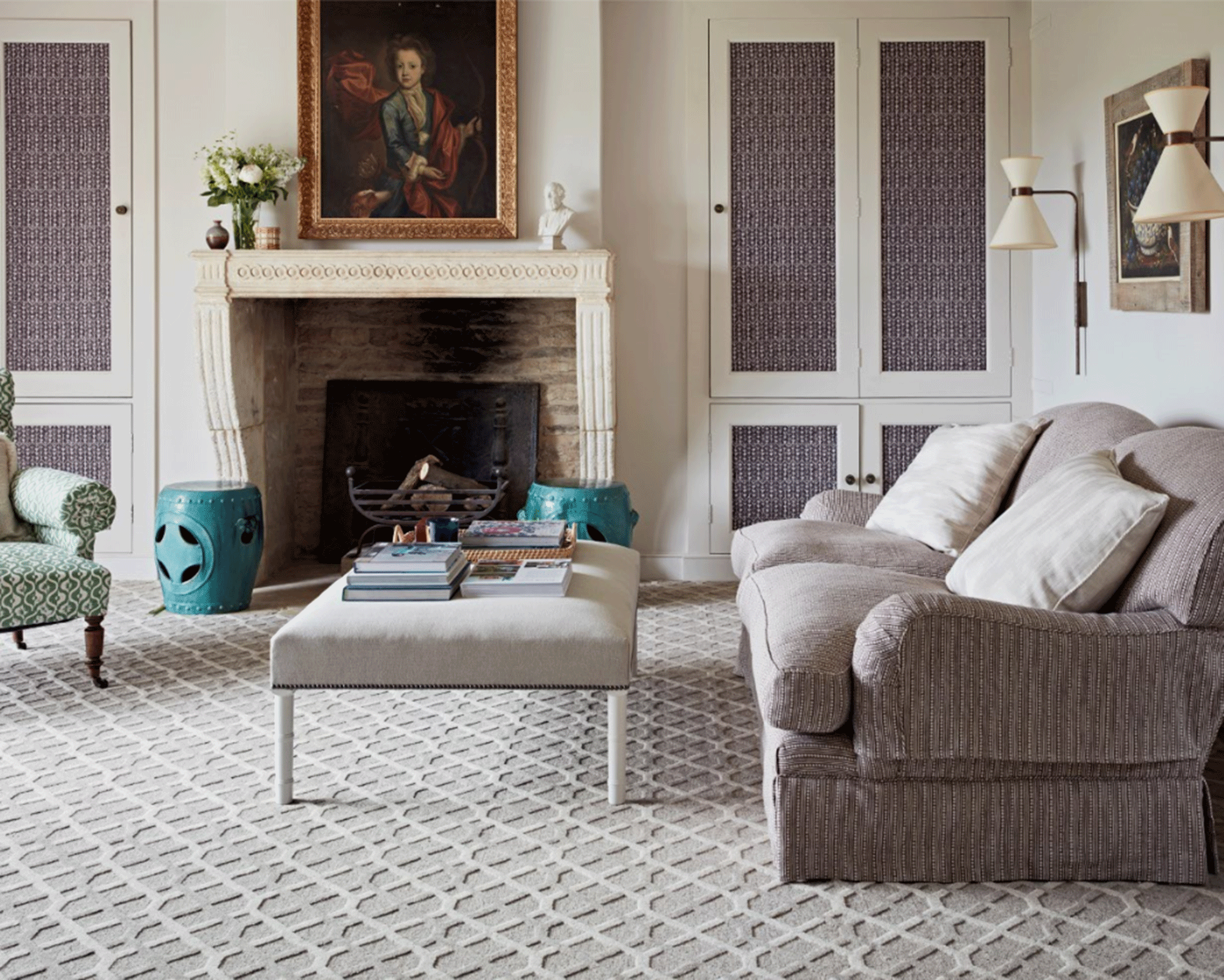 A traditional living room with textured light grey carpet, light grey sofa, and cream mantelpiece