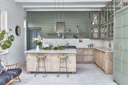 A green toned kitchen with wooden elements