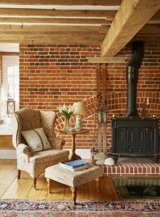 brick-wall-with-wood-burning-stove-arm-chair-and-footstool
