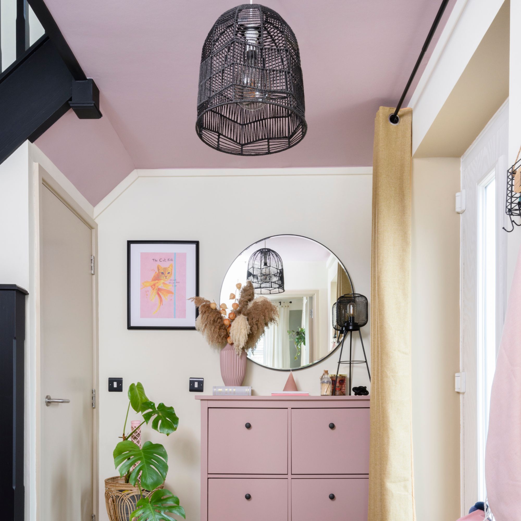 a white room with pink and black accents, with a painted pale pink ceiling