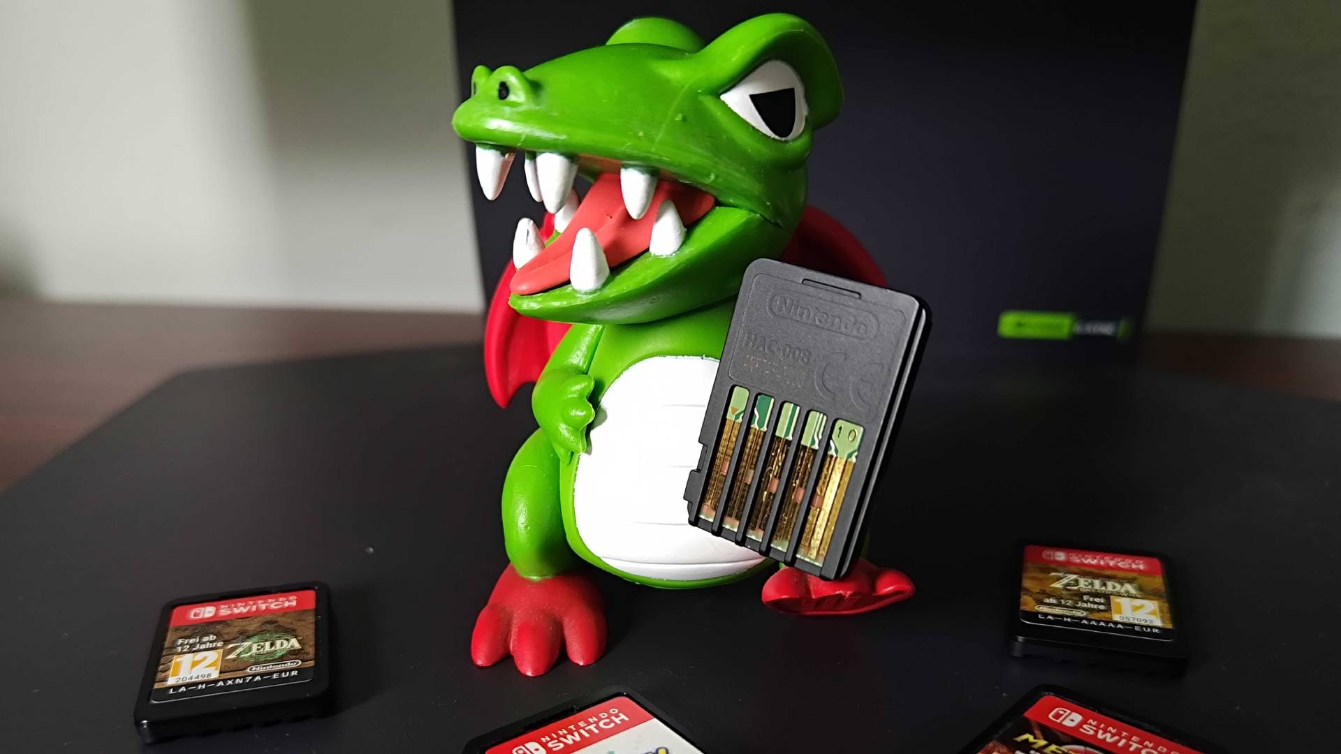 Dragon figure from Dig-Dug holding Switch cartridge