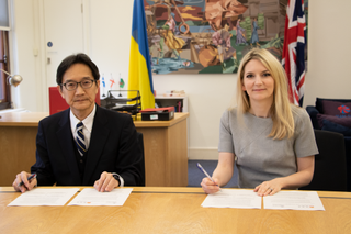 Yuji Sasaki and Julia Lopez signing the agreement