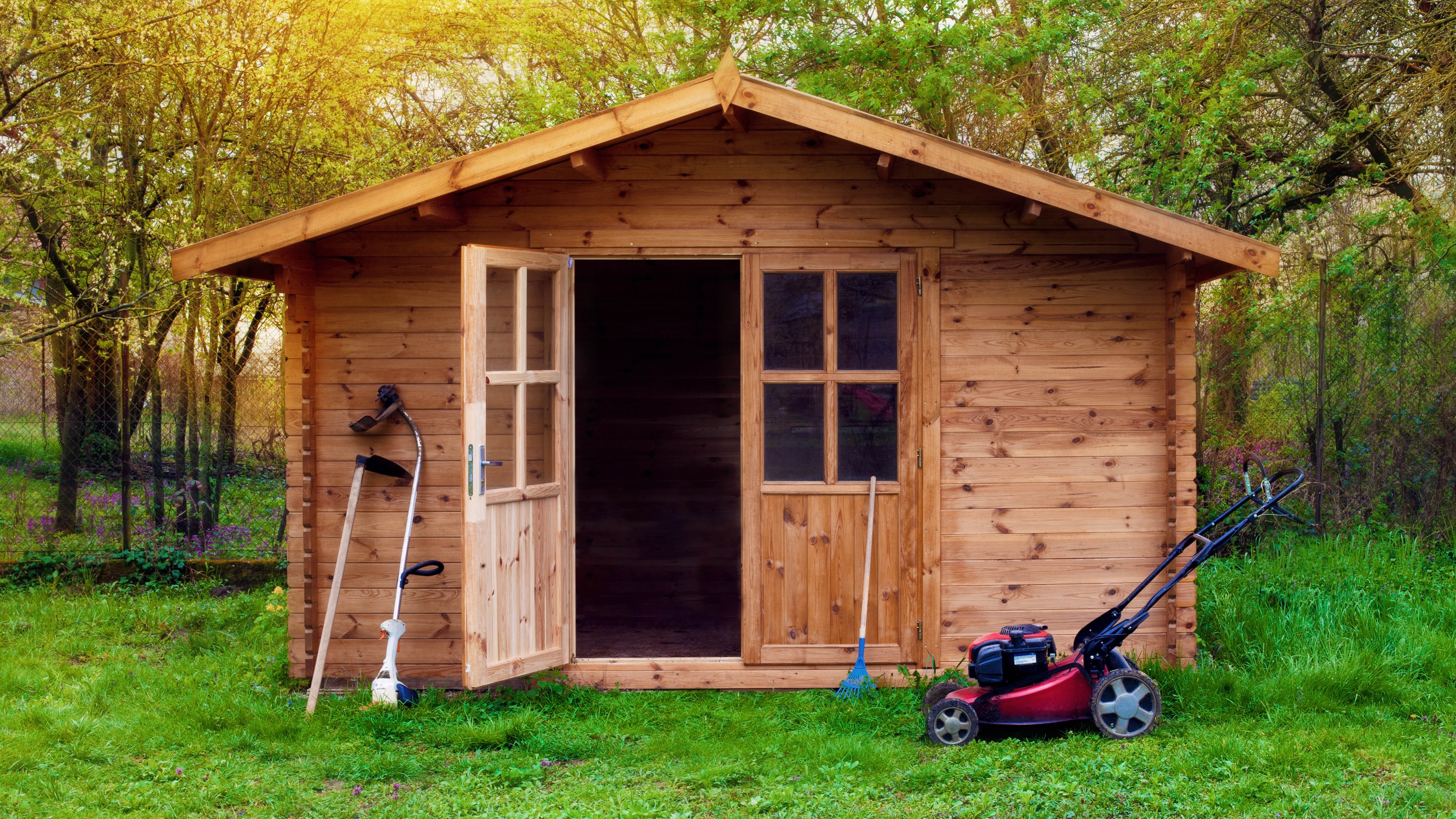 A lawnmower in front of a shed