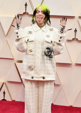 Billie Eilish with neon green roots and oversized Chanel suit