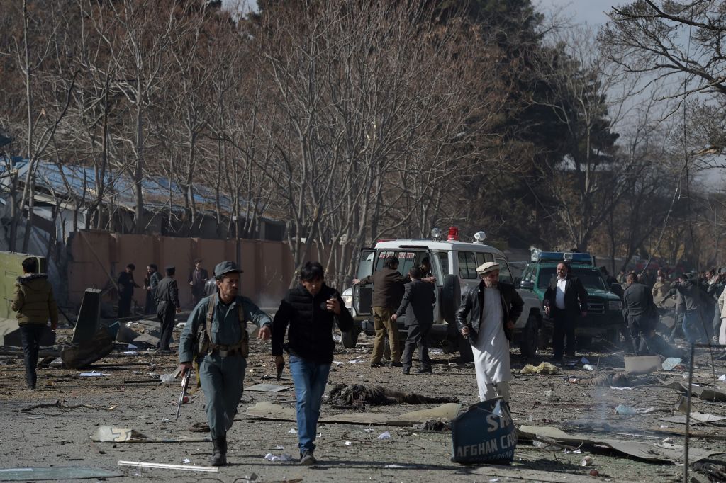 Afghan volunteers and policemen carry injured men on an ambulance at the scene of a car bomb exploded in front of the old Ministry of Interior building in Kabul on January 27, 2018. 